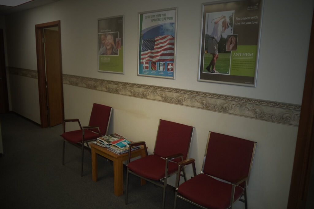 Chairs in waiting room with promotional pictures on wall at Lowry Hearing Aid Center in Nevada